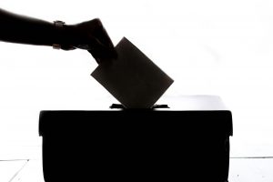 Wahlurne mit Hand und Briefumschlag