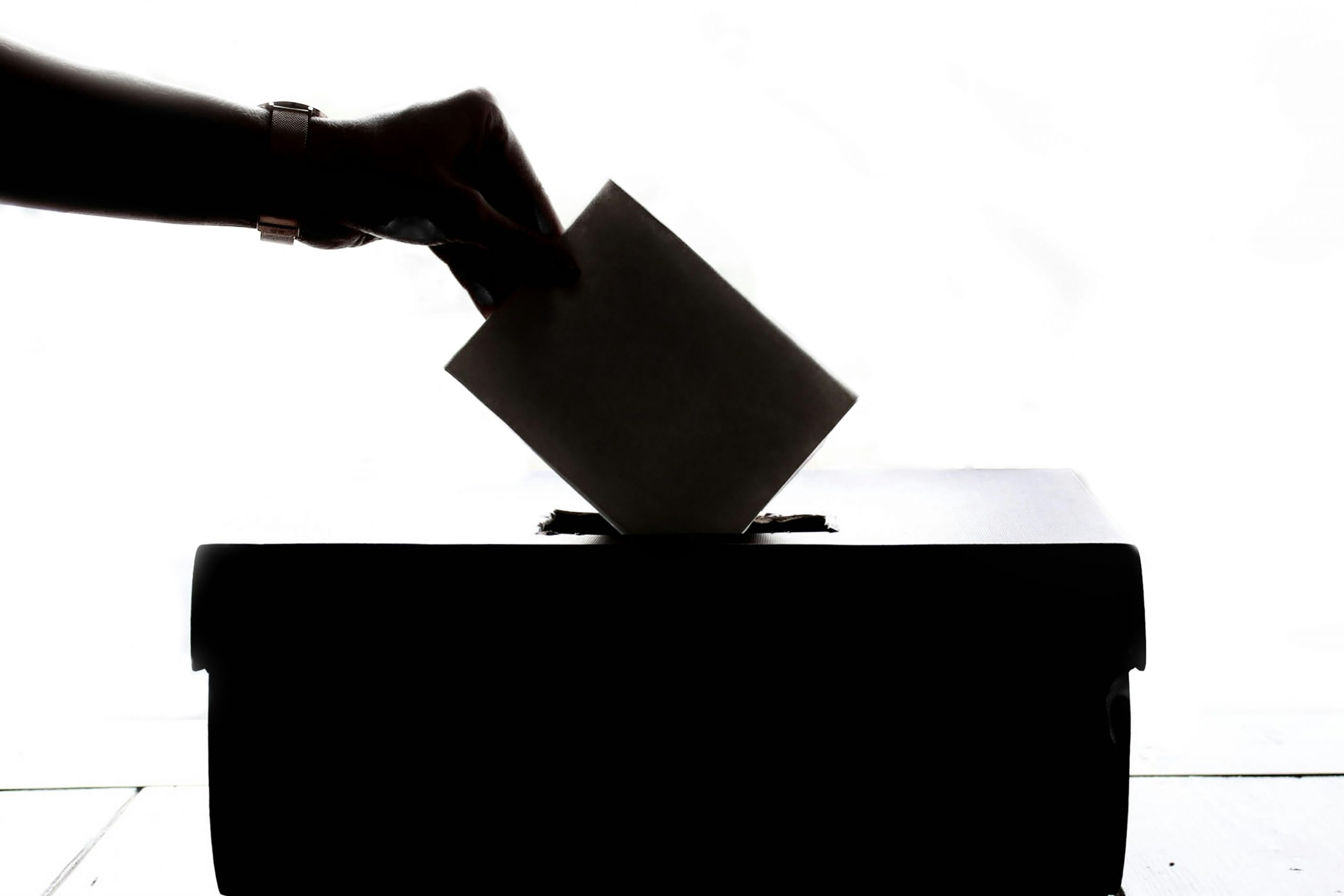 Wahlurne mit Hand und Briefumschlag